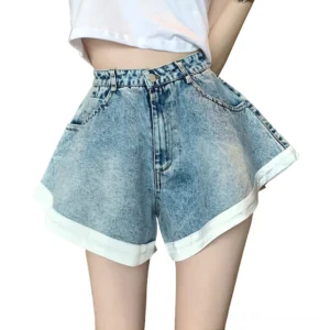 High-waist acid wash denim ruffle shorts front view with white rolled cuffs on female model