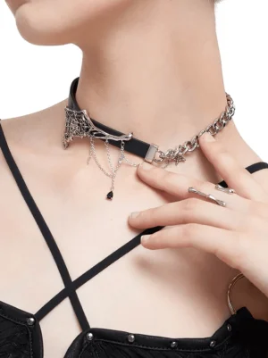 Asymmetrical gothic choker on female model wearing black camisole - chest and neck front view