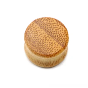 Solid natural bamboo wood ear gauge flesh tunnel expander - studio flat lay showing organic grain texture and warm honey tone