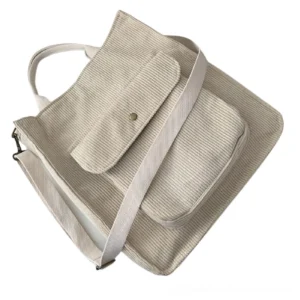 Beige corduroy gothic tote crossbody bag with wide adjustable strap, elevated angled view showing soft neutral dark academia style