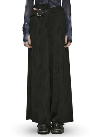 Black asymmetrical buckle gothic wide leg pants front view - model wearing full length trousers with silver metal buckle and wavy texture knit fabric
