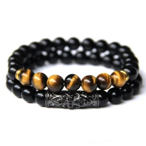 Stacked unisex beaded bracelets in black with matte beads and dark metal decor, alternative jewelry flat lay