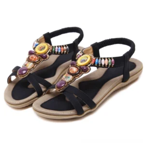 Black beaded gothic sandals with colorful gemstone embellishment, elastic ankle strap, oblique top view on white background