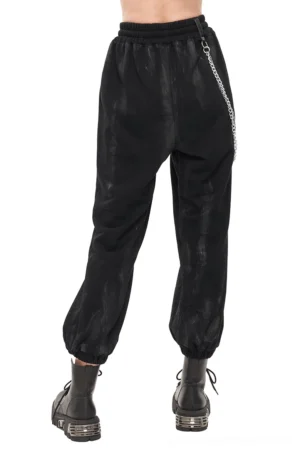Distressed black gothic cargo pants with faded paint finish and metal chain accents, front angled view on model