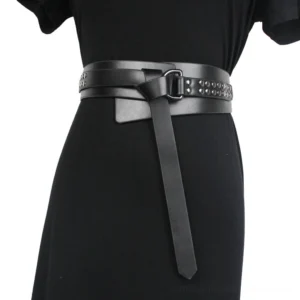 Woman wearing black gothic studded corset belt with three-quarter front waist view, demonstrating fit and metal buckle hardware