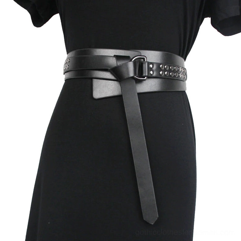 Woman wearing black gothic studded corset belt with three-quarter front waist view, demonstrating fit and metal buckle hardware