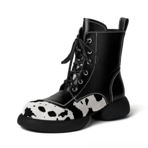 Black cow print gothic ankle boots with lace-up closure and chunky platform sole, front studio view