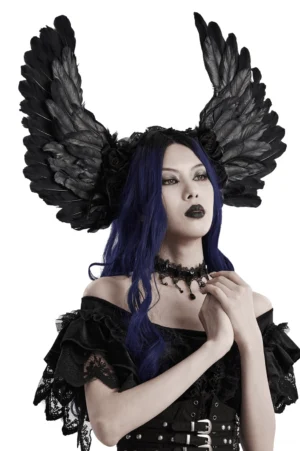Black feather devil wings headband worn by model with dark blue wavy hair, front three-quarter view showcasing gothic dark angel aesthetic with black roses and feather details