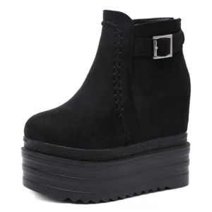Single black platform ankle boot with flock lining, front three-quarter view showing buckle and stitched trim on white studio background