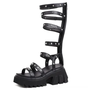 Black patent leather gladiator platform sandals with metal studs and back zipper - left profile view showing chunky lug sole and straps