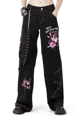 Black gothic cargo pants with pink skull graffiti print and metal chain details front view on model