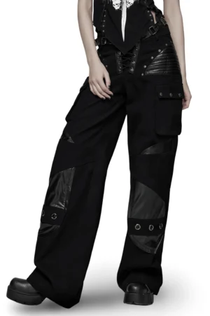 Black gothic low-waist cargo pants with leather patches, metal rivets, and adjustable belt worn by model - frontal view