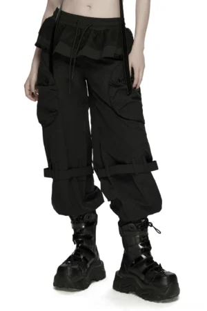 Black gothic cargo pants with mesh waist worn by model, front view showcasing relaxed silhouette and adjustable straps