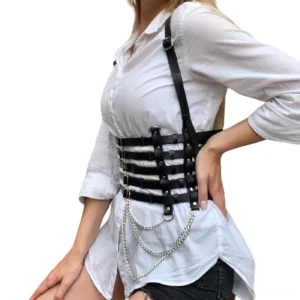 Black synthetic leather chest harness Y-shaped back design with silver metal chains, worn over white casual top, lateral view