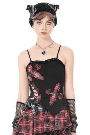 Black gothic corset cami top with red tartan cross patches and side lace-up detail, front view on fashion model wearing fishnets and combat boots