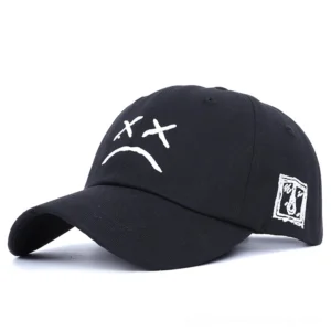 Black gothic crying face baseball cap with embroidered sad expression, front studio view, unisex dark aesthetic cotton hat with geometric patch detail