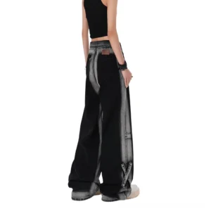 Back view of black gothic alternative denim jeans showing authentic leather patch, worn with black crop top