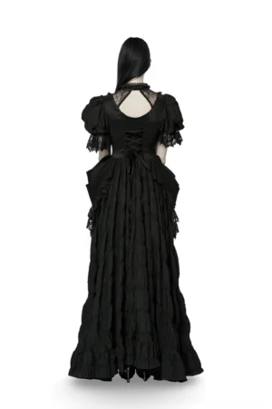 Black gothic evening gown rear view showing dramatic lace-up corset back cutout and layered ruffled skirt on mannequin