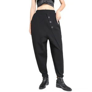 Black gothic harem pants with asymmetrical decorative buttons and drop crotch design, front view worn by female model