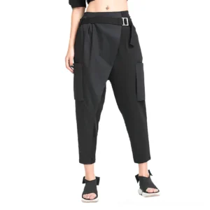 Black gothic harem pants front view on model, showing asymmetrical spliced panels and high-waisted silhouette with D-ring belt