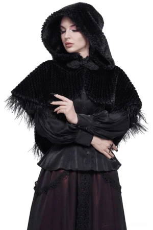 Black gothic hooded cape with feather trim and pom-pom details on female model, three-quarter front view against white studio background