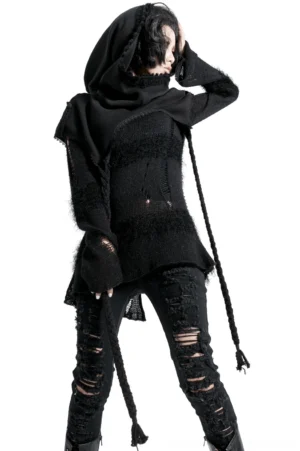 Black hooded gothic wool cape worn by female model in front three-quarter view, displaying frayed fuzzy knit texture and braided hanging tassels on white studio background