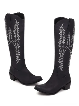 Black gothic knee-high cowboy boots with silver embroidery details and pointed toe design on white background