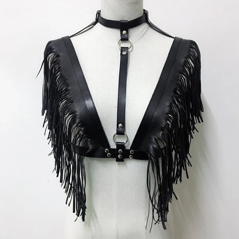Close-up front view of black leather gothic harness top with deep V neckline, central metal rings, and tassel shoulder accents