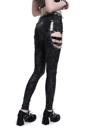 Back view of black gothic trousers with patent leather flap pockets and studded waist hardware on female model