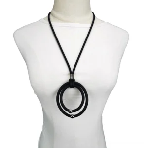 Black gothic rubber cord pendant necklace with dual round pendants and metal accents worn on white mannequin