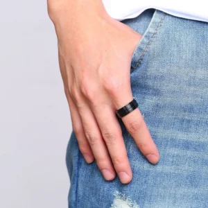 Black gothic groove ring worn on male hand, casual everyday styling with denim