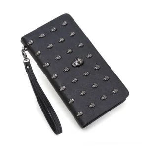 Black gothic skull studded long wallet with silver rivets and central skull decoration, shown from left oblique angle with detachable wrist strap