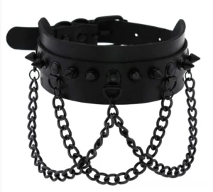 Black vegan leather spiked gothic choker with adjustable buckle strap, flat lay studio shot displaying cone stud details and hanging metal chains