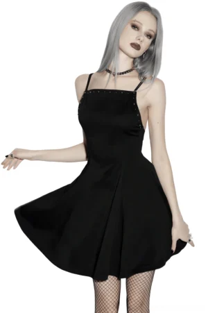 Black gothic studded A-line mini slip dress with square neckline, worn with fishnet stockings, front three-quarter view