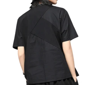 Black grommet t-shirt back view showing asymmetrical design and rear three-quarter silhouette with geometric patchwork detail