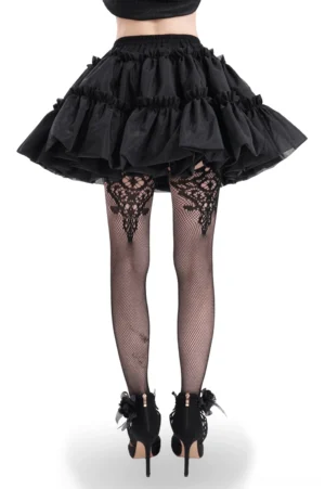 Back view of black gothic ruffled tulle skirt featuring layered tiered construction and elastic waistband, worn with lace thigh-high stockings
