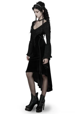 Black gothic velvet high-low dress side profile showing asymmetrical hem, sheer stockings, and platform boots worn by goth model