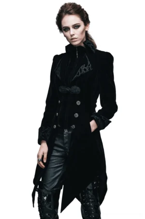 Black gothic velvet tailcoat with embroidered collar and cuffs, front three-quarter view on female model showing asymmetrical hem and fitted waist