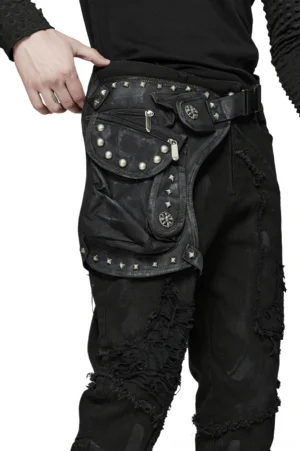 Black gothic waist bag with studded pocket trims and adjustable straps worn on male torso with black long-sleeve top, front lateral view