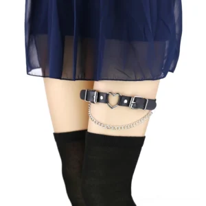 Black PU leather heart chain garter belt worn on thigh with stockings, showing side profile with dangling silver chain pendant