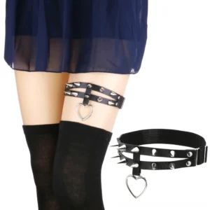 Black spiked heart thigh garter belt on model wearing fishnet stockings, side view showing double strap punk leg harness with silver rivets