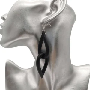 Black interlocking teardrop rubber earrings displayed on silver mannequin bust, showcasing neo-gothic handmade drop earring design with matte finish and silver ear hooks from side angle