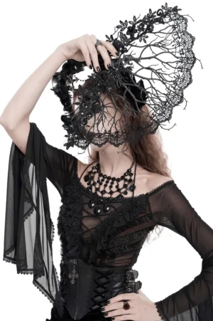 Gothic woman from behind holding ornate black lace hand fan with filigree branch structure, displaying fan placement in dark romantic ensemble