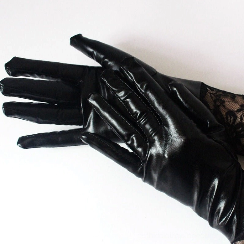 Pair of black lace gothic gloves flat lay, close-up top view displaying finger joints and glossy faux leather surface