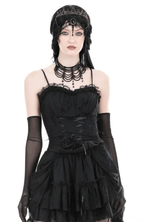 Front view of black lace-up bustier corset with scalloped lace trim, modeled on gothic woman with sheer gloves and ruffled skirt on white studio background