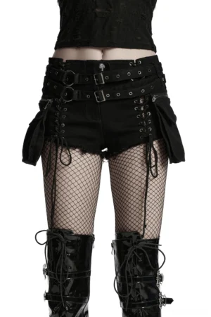 Front full-body view of black gothic punk lace-up shorts with double metal buckle belts and detachable side pouches worn by model in white studio setting