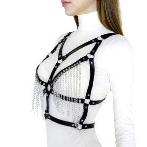 Black faux leather chain body harness worn on model, front left view with silver tassel chains and geometric cross strapping detail