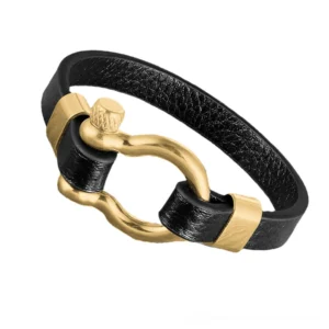 Two-tone black leather and gold stainless steel toggle clasp bracelet with screw shackle detail, angled view