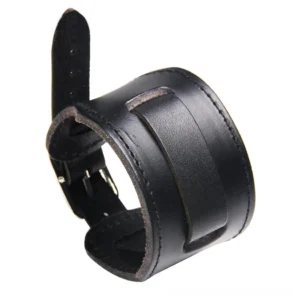 Black wide leather gothic wristband with metal hardware and embellished panel, matte finish leather texture, three-quarter view on clean white surface