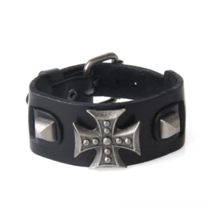 Black leather gothic cross bracelet flat lay, displaying metal cross ornament and adjustable strap with toggle clasp